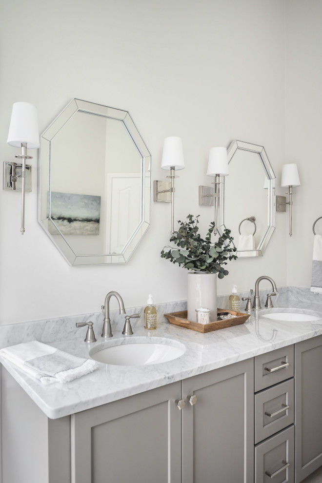 Inspiration for a large traditional ensuite bathroom in Charlotte with shaker cabinets, grey cabinets, a corner shower, a two-piece toilet, white tiles, porcelain tiles, white walls, porcelain flooring, a submerged sink, marble worktops, beige floors, a hinged door and grey worktops.
