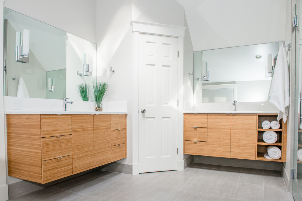 Exemple d'une grande douche en alcôve principale chic en bois clair avec un placard à porte plane, une baignoire d'angle, WC séparés, un carrelage blanc, un mur blanc, un sol en carrelage de céramique et un lavabo encastré.
