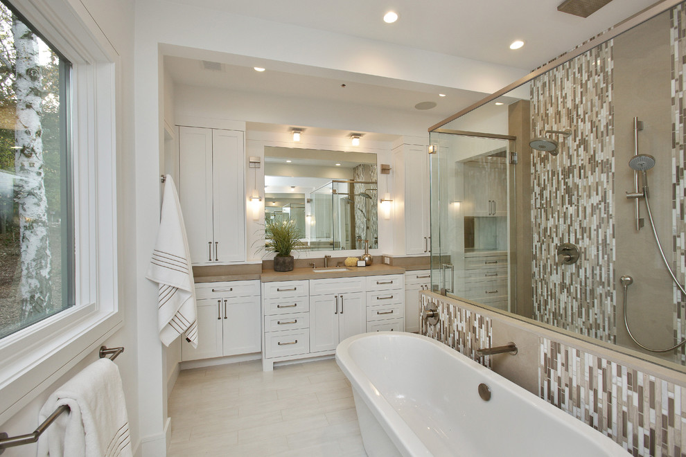 Diseño de cuarto de baño campestre con armarios estilo shaker, puertas de armario blancas y encimera de piedra caliza