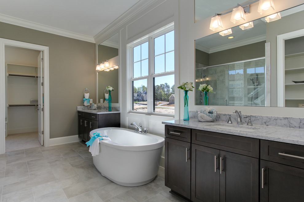 Exempel på ett stort klassiskt en-suite badrum, med luckor med infälld panel, grå skåp, ett fristående badkar, beige kakel, keramikplattor, klinkergolv i keramik, ett undermonterad handfat och marmorbänkskiva