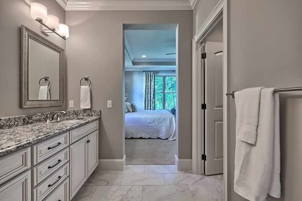 Klassisk inredning av ett stort en-suite badrum, med ett konsol handfat, ett badkar i en alkov, en dusch/badkar-kombination, grå kakel och grå väggar