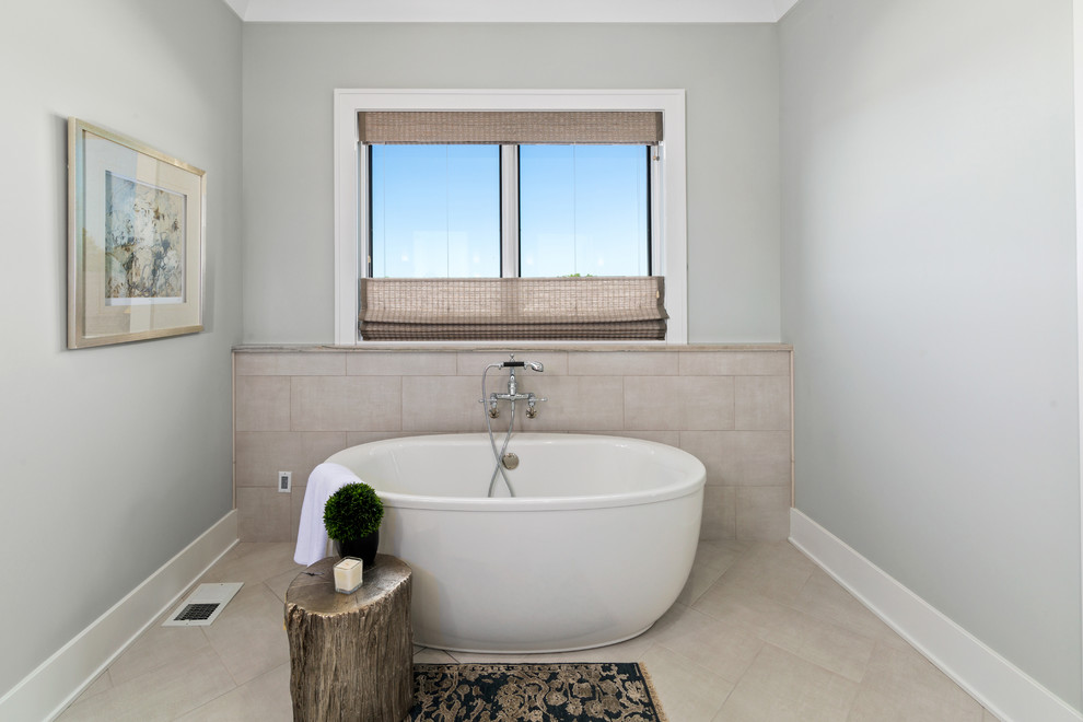 Foto de cuarto de baño campestre con bañera exenta, baldosas y/o azulejos beige, paredes azules y suelo beige
