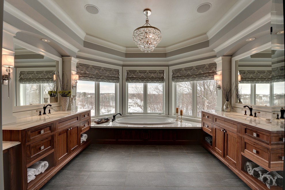 Foto de cuarto de baño clásico con lavabo bajoencimera, puertas de armario de madera en tonos medios, baldosas y/o azulejos negros y bañera encastrada