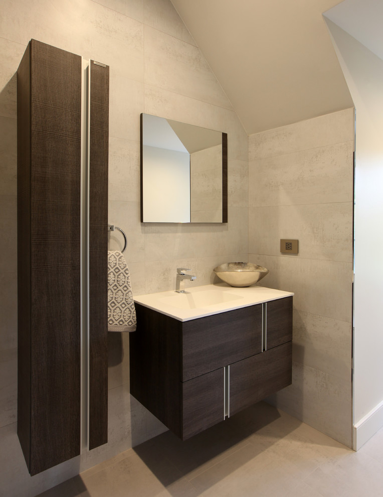 Inspiration pour une très grande salle de bain design en bois foncé avec un lavabo intégré, un placard à porte plane, un plan de toilette en marbre, WC séparés, un carrelage beige, des dalles de pierre et un sol en bois brun.