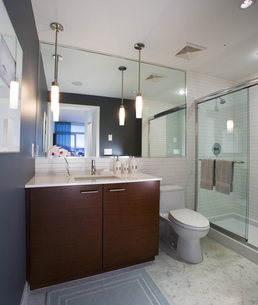 На фото: ванная комната в современном стиле с врезной раковиной, плоскими фасадами, темными деревянными фасадами, унитазом-моноблоком и белой плиткой