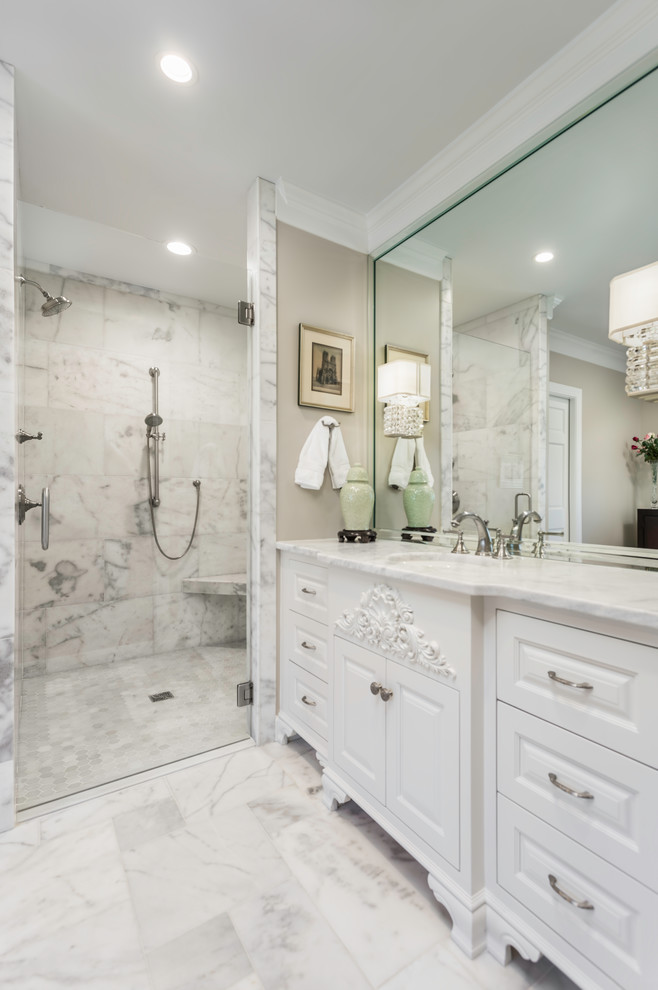 Idéer för stora vintage vitt en-suite badrum, med luckor med upphöjd panel, vita skåp, ett fristående badkar, en kantlös dusch, vit kakel, marmorkakel, vita väggar, marmorgolv, ett integrerad handfat, marmorbänkskiva, vitt golv och dusch med gångjärnsdörr