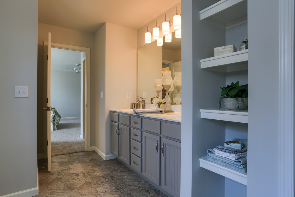 Modelo de cuarto de baño principal clásico renovado extra grande con armarios con paneles empotrados, puertas de armario grises, baldosas y/o azulejos beige, paredes beige, lavabo integrado, encimera de mármol y suelo gris