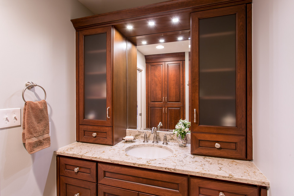 Example of a mid-sized classic beige tile and porcelain tile porcelain tile bathroom design in Raleigh with an undermount sink, raised-panel cabinets, medium tone wood cabinets, quartzite countertops and green walls