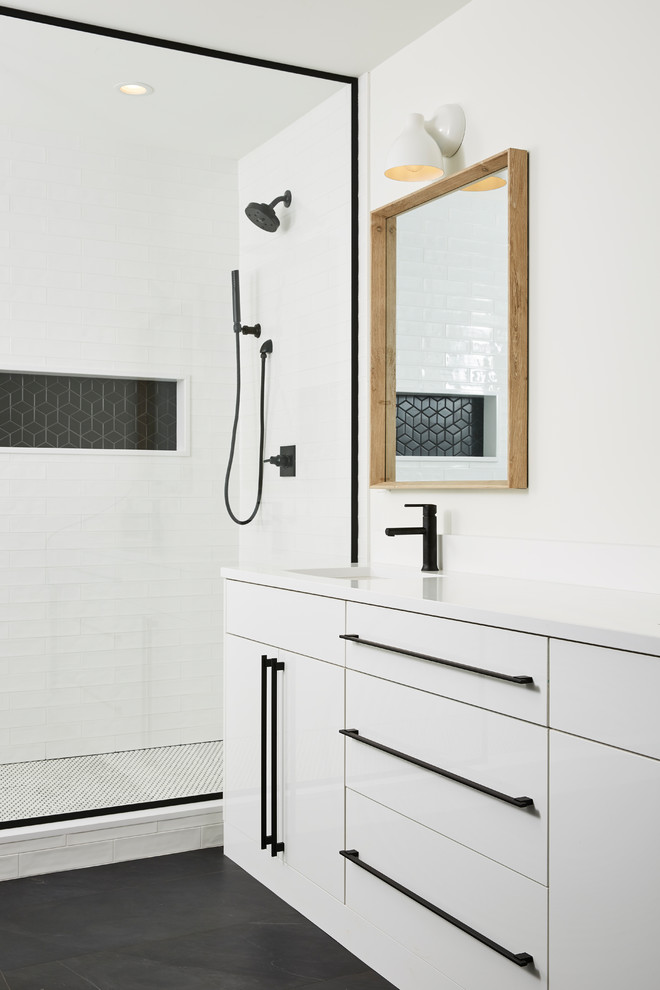 Стильный дизайн: ванная комната в современном стиле с плоскими фасадами, белыми фасадами, душем в нише, черной плиткой, черно-белой плиткой, белой плиткой, плиткой кабанчик, белыми стенами, душевой кабиной, врезной раковиной, черным полом и белой столешницей - последний тренд