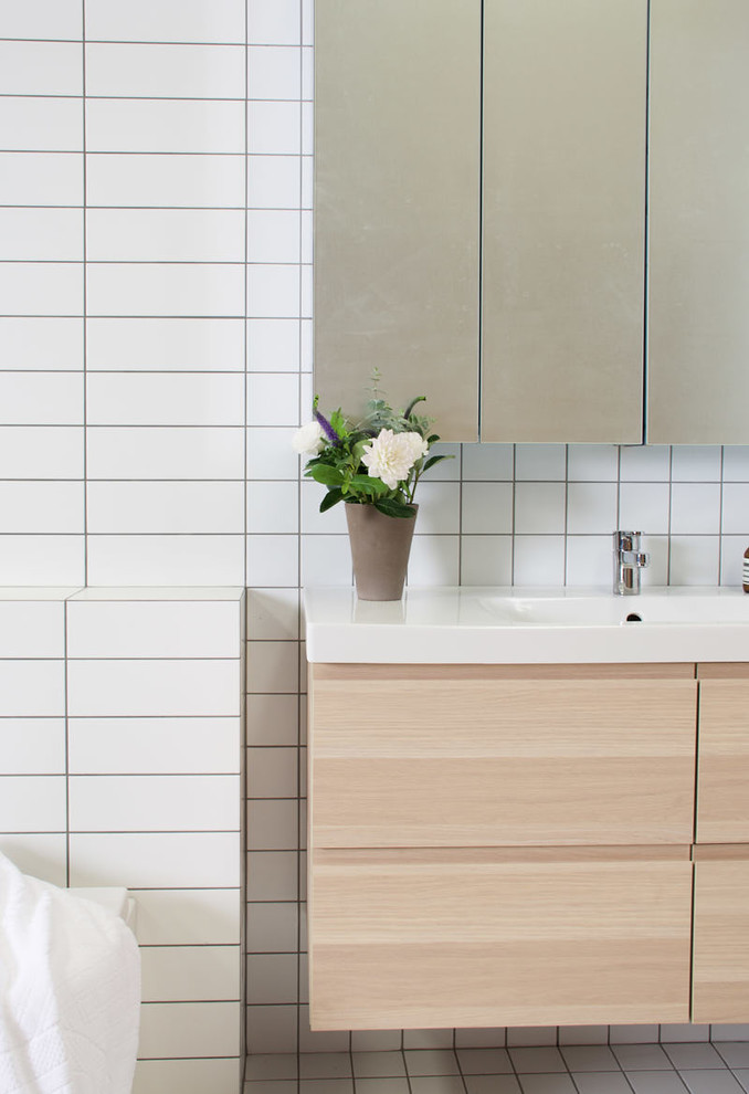 Immagine di una stanza da bagno con doccia nordica di medie dimensioni con WC a due pezzi, piastrelle bianche, piastrelle diamantate, pareti bianche, pavimento con piastrelle in ceramica e lavabo sospeso