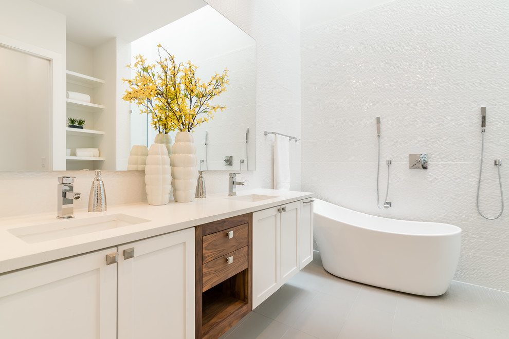 Modern inredning av ett vit vitt en-suite badrum, med skåp i shakerstil, vita skåp, ett fristående badkar, en dubbeldusch, vit kakel, vita väggar, ett undermonterad handfat, vitt golv och med dusch som är öppen