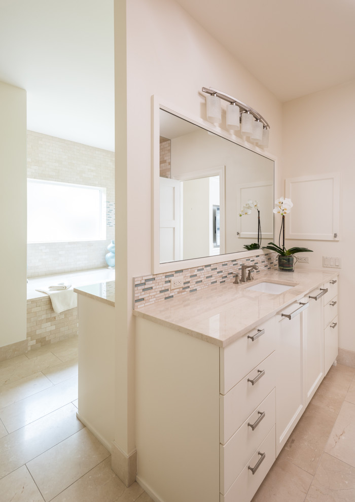 Example of a large beach style master beige tile and glass tile cement tile floor and beige floor bathroom design in Austin with flat-panel cabinets, white cabinets, a two-piece toilet, beige walls, a drop-in sink and laminate countertops