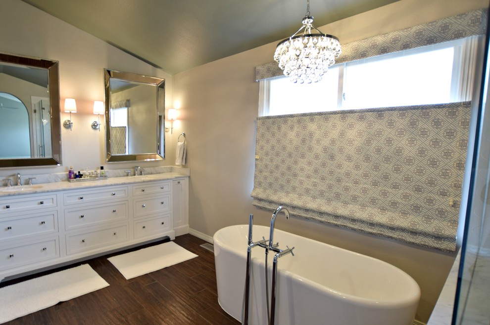 This is an example of a medium sized traditional ensuite bathroom in Denver with beaded cabinets, white cabinets, a freestanding bath and a submerged sink.