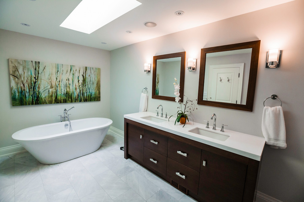Exemple d'une grande douche en alcôve principale moderne en bois foncé avec un lavabo encastré, un placard à porte plane, un plan de toilette en quartz, une baignoire indépendante, un carrelage gris, un carrelage de pierre, un mur gris et un sol en marbre.