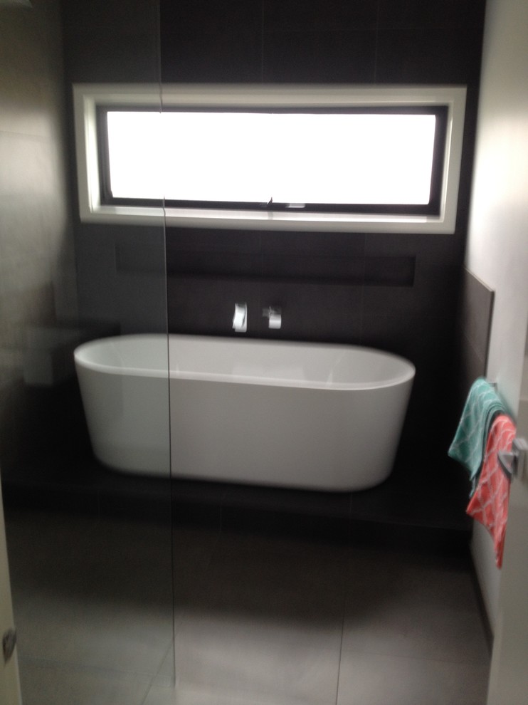 Industrial Badezimmer mit freistehender Badewanne, grauen Fliesen, Keramikfliesen, Keramikboden und grauem Boden in Sonstige