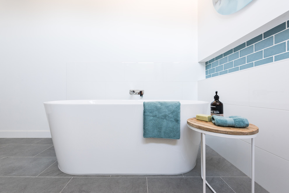 Пример оригинального дизайна: детская ванная комната среднего размера в современном стиле с плоскими фасадами, белыми фасадами, угловым душем, раздельным унитазом, керамической плиткой, белыми стенами, полом из керамогранита, настольной раковиной, столешницей из искусственного кварца, серым полом, душем с распашными дверями, белой столешницей, отдельно стоящей ванной и синей плиткой