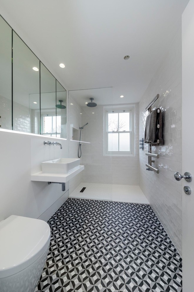 Inspiration för mellanstora klassiska vitt badrum med dusch, med en kantlös dusch, en vägghängd toalettstol, vit kakel, grå väggar, ett fristående handfat, flerfärgat golv och med dusch som är öppen