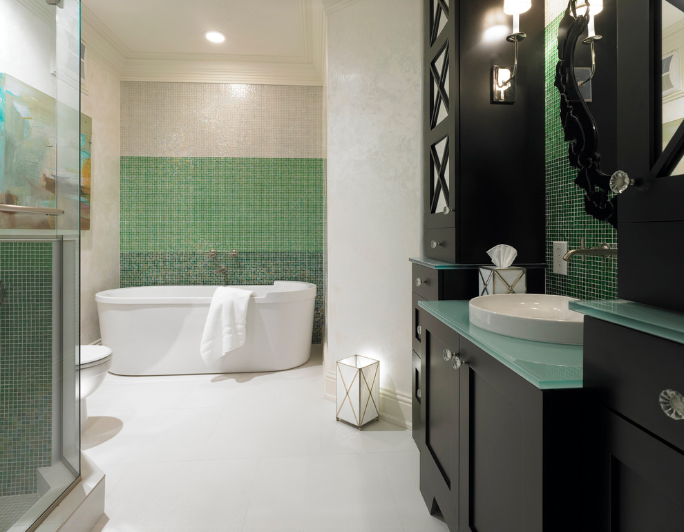 На фото: ванная комната в средиземноморском стиле с настольной раковиной, фасадами в стиле шейкер, черными фасадами, отдельно стоящей ванной, зеленой плиткой, плиткой мозаикой, белыми стенами, стеклянной столешницей и бирюзовой столешницей с