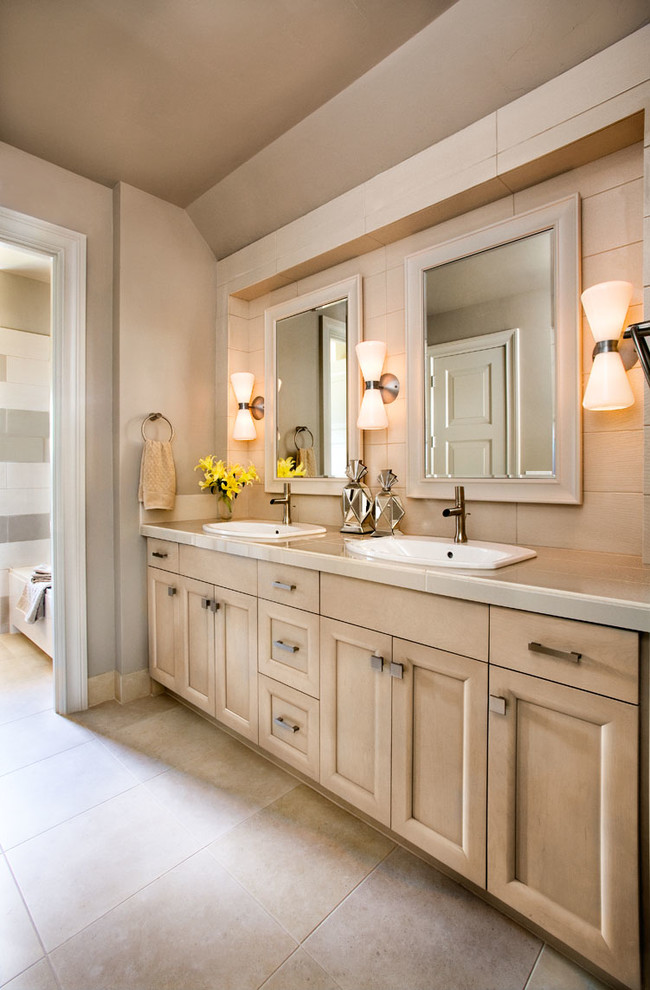 Réalisation d'une salle de bain tradition en bois clair avec un lavabo posé, un placard avec porte à panneau encastré et un mur beige.