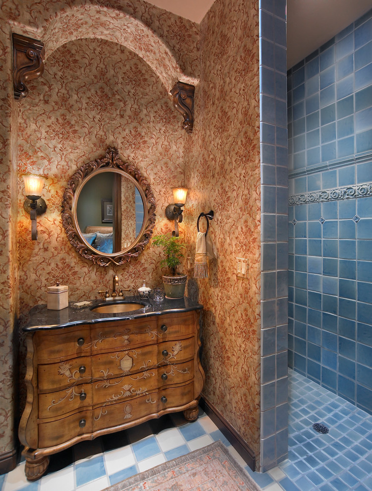 Cette image montre une salle d'eau méditerranéenne avec une douche ouverte, un carrelage bleu, des carreaux de céramique, un mur marron, aucune cabine et un placard à porte plane.