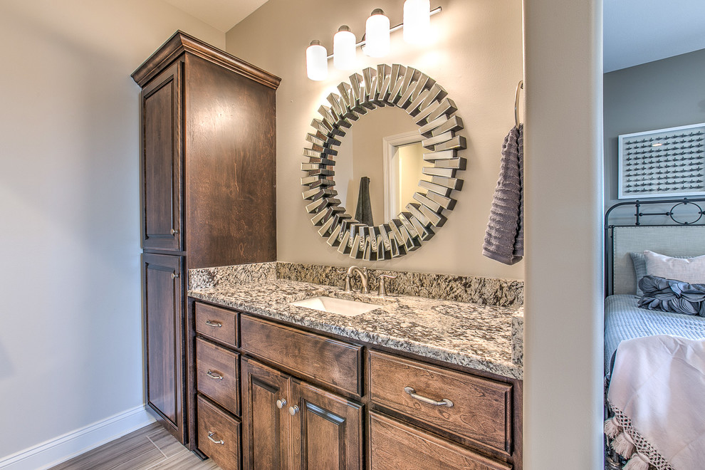 Medium sized classic bathroom in Omaha with raised-panel cabinets, medium wood cabinets, beige walls, light hardwood flooring, an integrated sink and granite worktops.