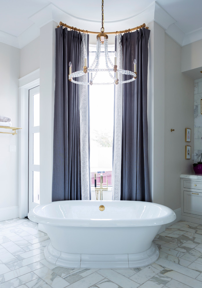 Inredning av ett klassiskt stort en-suite badrum, med luckor med infälld panel, grå skåp, ett fristående badkar, vita väggar, marmorgolv, marmorbänkskiva och vitt golv