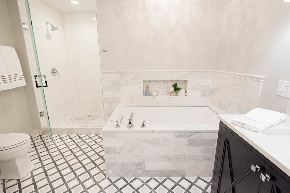 Photo of a medium sized traditional ensuite bathroom in Chicago with beaded cabinets, dark wood cabinets, a submerged bath, an alcove shower, a two-piece toilet, grey tiles, stone tiles, grey walls, marble flooring, a submerged sink and marble worktops.