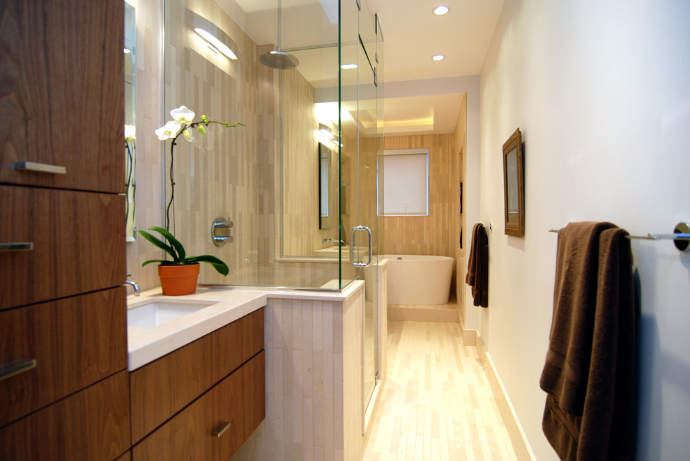 Aménagement d'une douche en alcôve principale contemporaine en bois foncé avec un lavabo encastré, un placard à porte plane, une baignoire indépendante, WC à poser, un carrelage beige, un carrelage de pierre et un mur blanc.