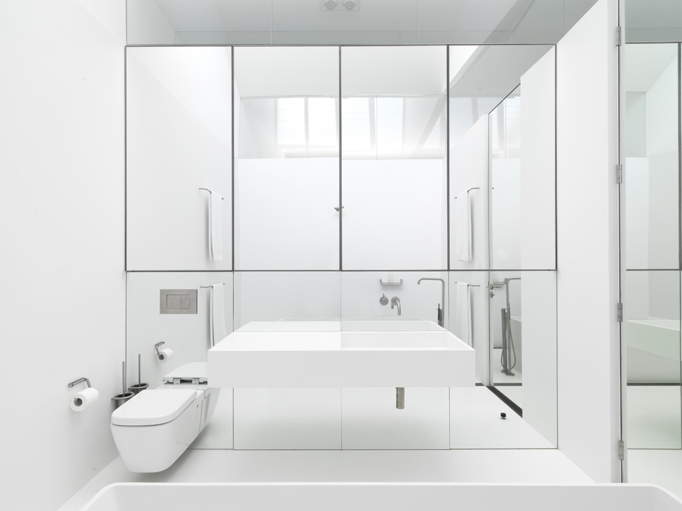 Example of a minimalist freestanding bathtub design in Sydney with a wall-mount sink and a wall-mount toilet