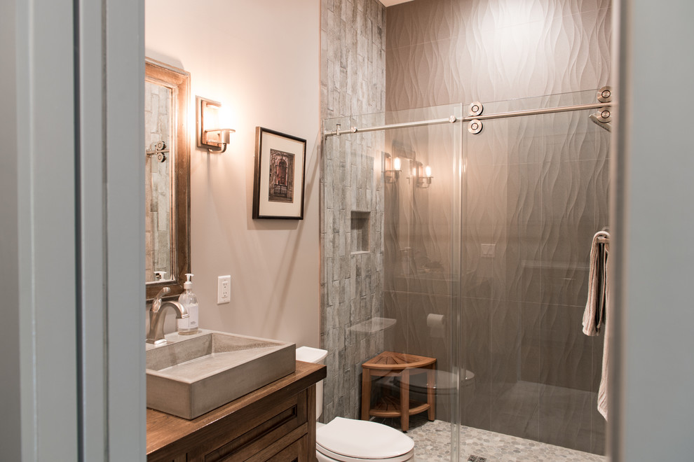 Design ideas for a medium sized rustic shower room bathroom in Charleston with recessed-panel cabinets, dark wood cabinets, an alcove shower, a two-piece toilet, grey tiles, porcelain tiles, grey walls, a vessel sink, wooden worktops, a sliding door and brown worktops.