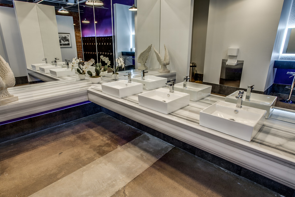 Foto di una stanza da bagno padronale industriale di medie dimensioni con pareti beige, pavimento in cemento, lavabo a bacinella e top in marmo