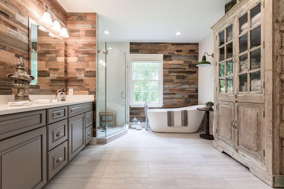 Photo of a rustic bathroom in DC Metro with raised-panel cabinets, grey cabinets, a freestanding bath, a corner shower, white walls, a submerged sink, beige floors, a hinged door and white worktops.