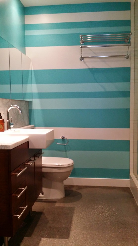 Idee per una piccola stanza da bagno tropicale con ante lisce, ante in legno scuro, pareti blu e pavimento in cemento
