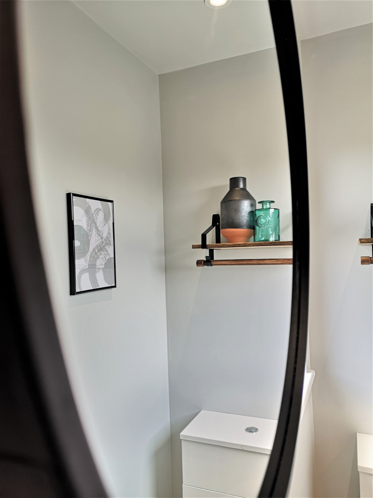 Cette photo montre une grande salle d'eau rétro avec des portes de placard blanches, un sol noir, meuble simple vasque et meuble-lavabo encastré.