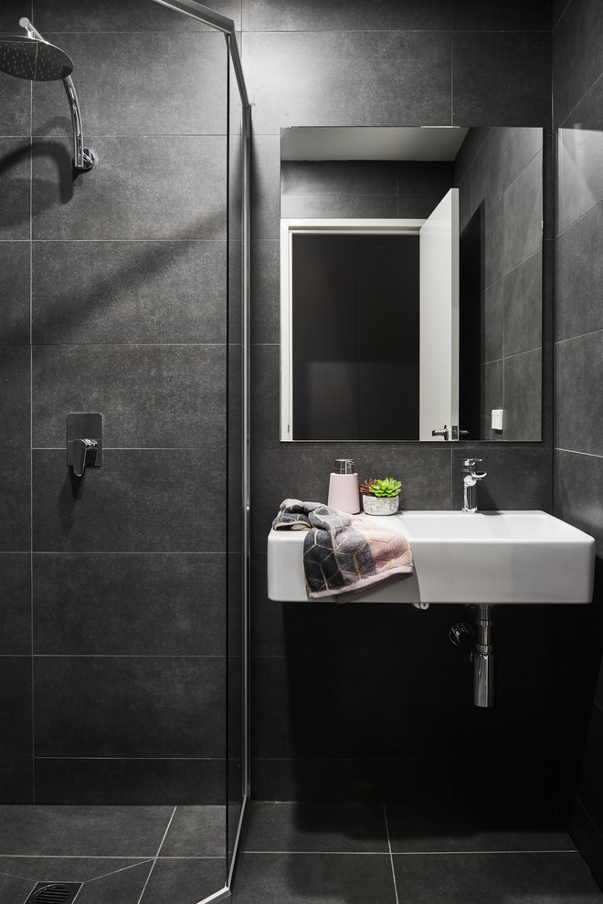 Inspiration for a small contemporary bathroom in Sydney with white cabinets, a corner shower, white tiles, porcelain tiles, black walls, porcelain flooring, a wall-mounted sink, black floors and a hinged door.