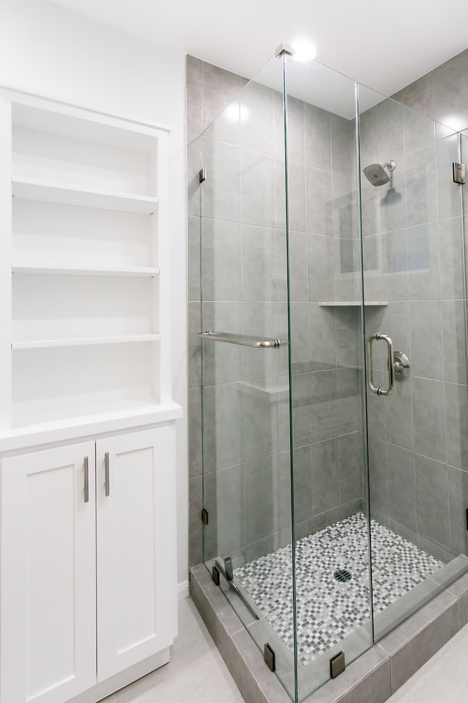 Идея дизайна: ванная комната среднего размера в стиле модернизм с фасадами в стиле шейкер, белыми фасадами, душем в нише, серой плиткой, белыми стенами, полом из керамической плитки и врезной раковиной