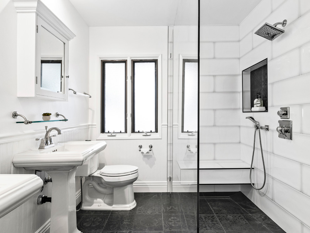 Foto på ett mellanstort vintage en-suite badrum, med vit kakel, porslinskakel, vita väggar, klinkergolv i porslin, svart golv, en dusch i en alkov och ett piedestal handfat