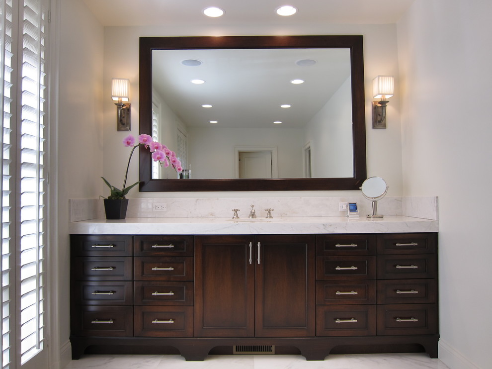 Example of a classic marble floor bathroom design in Los Angeles with shaker cabinets, dark wood cabinets, white walls, an undermount sink and marble countertops