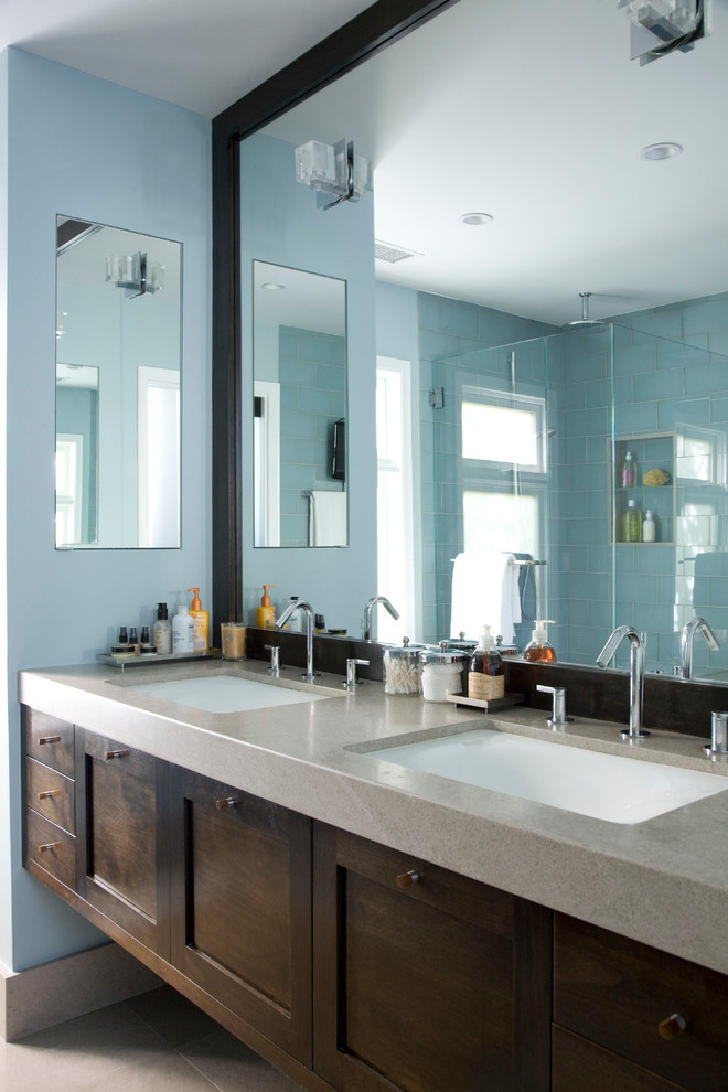 Cette photo montre une grande salle de bain principale chic en bois foncé avec un placard à porte shaker, une douche d'angle, un carrelage bleu, un carrelage en pâte de verre, un mur bleu, un sol en travertin, un lavabo encastré et un plan de toilette en granite.