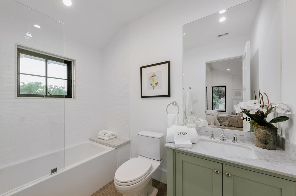 На фото: детская ванная комната среднего размера в стиле кантри с плоскими фасадами, зелеными фасадами, душем над ванной, раздельным унитазом, белой плиткой, керамической плиткой, белыми стенами, полом из мозаичной плитки, врезной раковиной, столешницей из кварцита, коричневым полом, душем с распашными дверями и белой столешницей