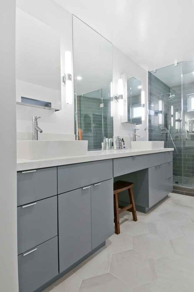 Пример оригинального дизайна: большая главная ванная комната в современном стиле с стеклянными фасадами, серыми фасадами, угловым душем, серой плиткой, керамогранитной плиткой, серыми стенами, полом из цементной плитки, настольной раковиной, столешницей из искусственного камня, серым полом, душем с распашными дверями и белой столешницей