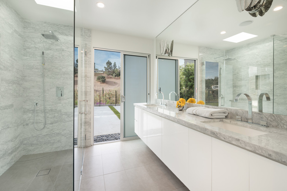 На фото: ванная комната в современном стиле с плоскими фасадами, белыми фасадами, угловым душем, белыми стенами, врезной раковиной, серым полом и серой столешницей с