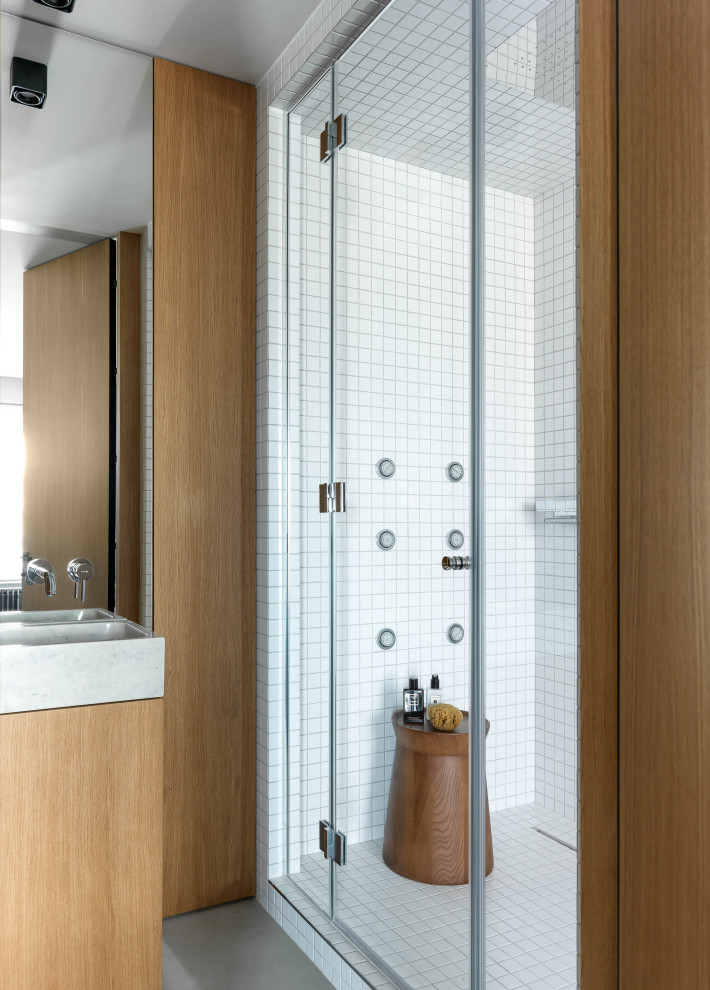Cette image montre une douche en alcôve design en bois brun avec un placard à porte plane, un carrelage blanc, mosaïque, un plan vasque, un sol gris et meuble simple vasque.