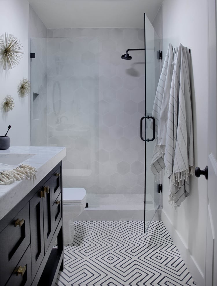 Immagine di una stanza da bagno con doccia minimalista di medie dimensioni con piastrelle grigie, piastrelle di cemento, ante con riquadro incassato, ante in legno bruno, doccia ad angolo, WC monopezzo, pareti grigie, pavimento in cemento, lavabo da incasso e top in marmo