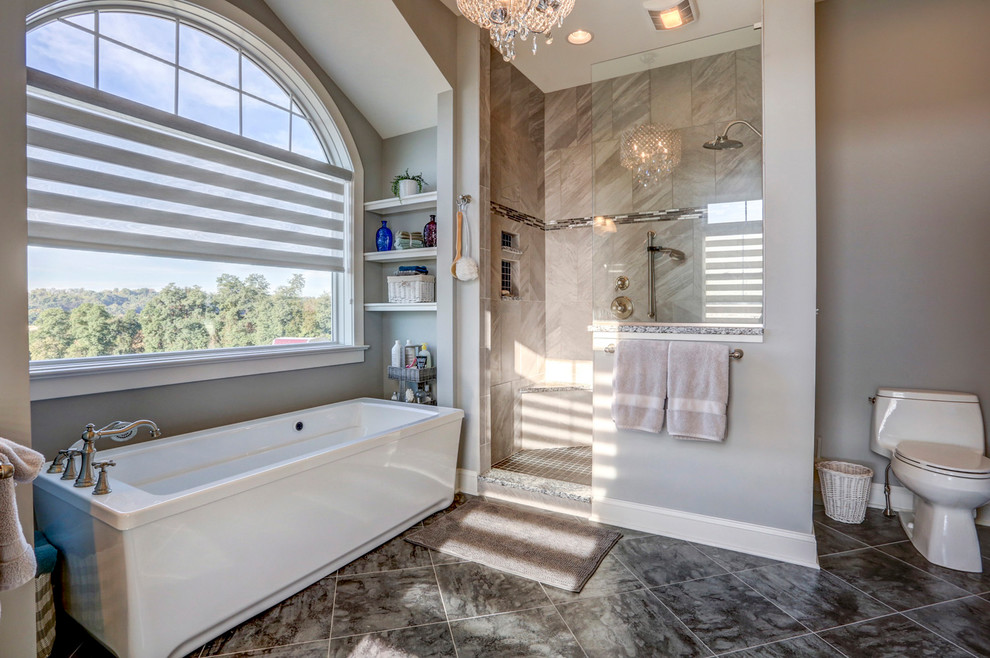 На фото: главная ванная комната в классическом стиле с отдельно стоящей ванной, открытым душем, душем в нише, раздельным унитазом, серой плиткой, серыми стенами и серым полом с