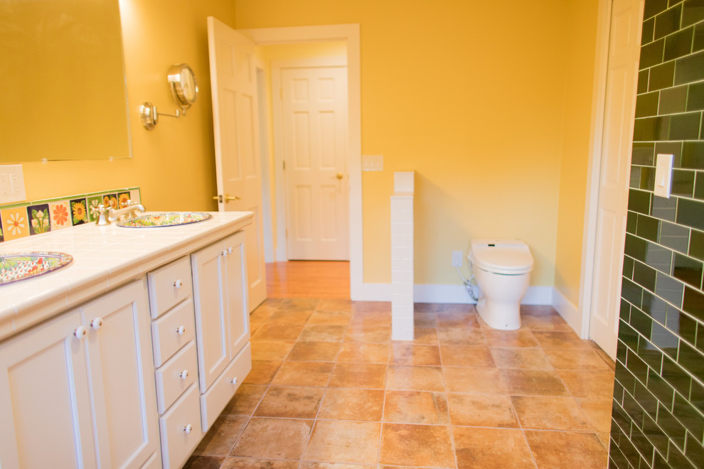 На фото: большая главная ванная комната в средиземноморском стиле с белыми фасадами, унитазом-моноблоком, белой плиткой, плиткой кабанчик, желтыми стенами, полом из терракотовой плитки, накладной раковиной, столешницей из плитки, красным полом и открытым душем