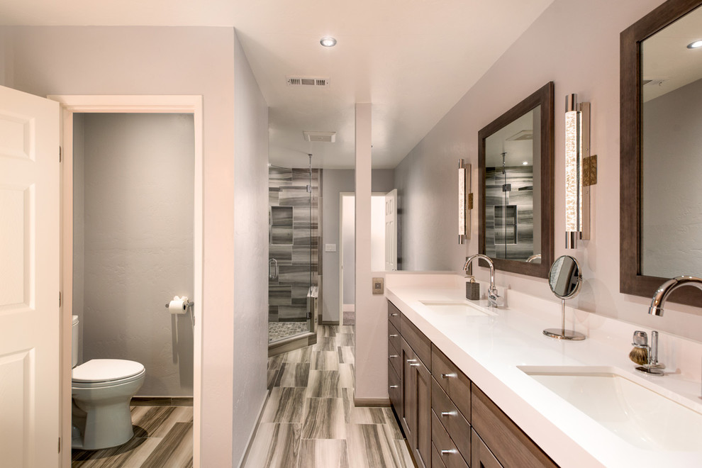 Bathroom - large contemporary master gray tile and ceramic tile ceramic tile and gray floor bathroom idea in San Diego with raised-panel cabinets, brown cabinets, a two-piece toilet, gray walls, an undermount sink, quartz countertops and a hinged shower door