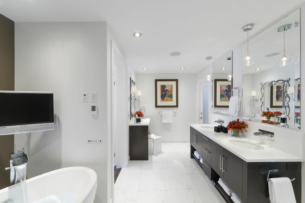 Inspiration for a large contemporary ensuite bathroom in Ottawa with a submerged sink, flat-panel cabinets, dark wood cabinets, a freestanding bath, white tiles, white walls, marble worktops and marble flooring.