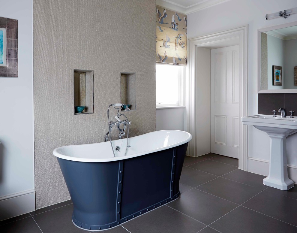 Inspiration for a large beach style ensuite bathroom in Oxfordshire with a freestanding bath, brown tiles, ceramic tiles, beige walls, ceramic flooring and a pedestal sink.