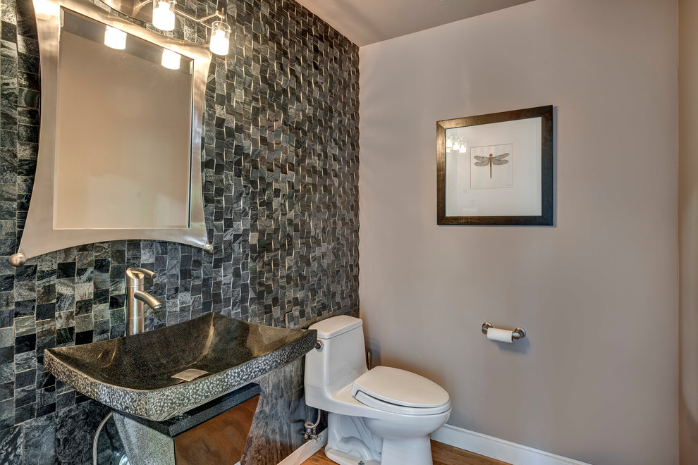 Réalisation d'un WC et toilettes minimaliste de taille moyenne avec un carrelage gris, un mur gris et parquet clair.